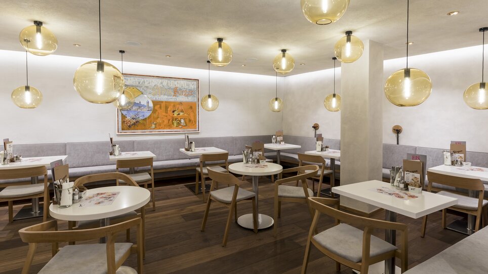 Vista moderna del ristorante con luci ovali e dettagli in legno. | © Werner Krug