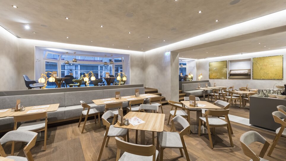 Panetteria moderna con tavoli in legno e decorazioni eleganti a Graz. | © Werner Krug
