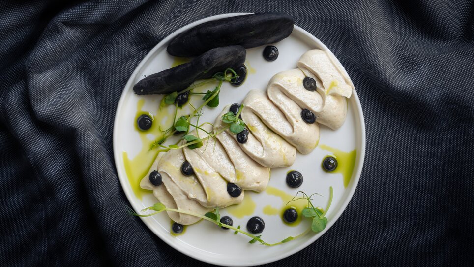 Un piatto artisticamente impiattato con mousse, mirtilli e verdure. | © Muamer Gazibegovic