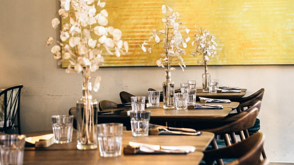 Zona ristorante accogliente con decorazioni eleganti e fiori. | © Ulrike Rauch