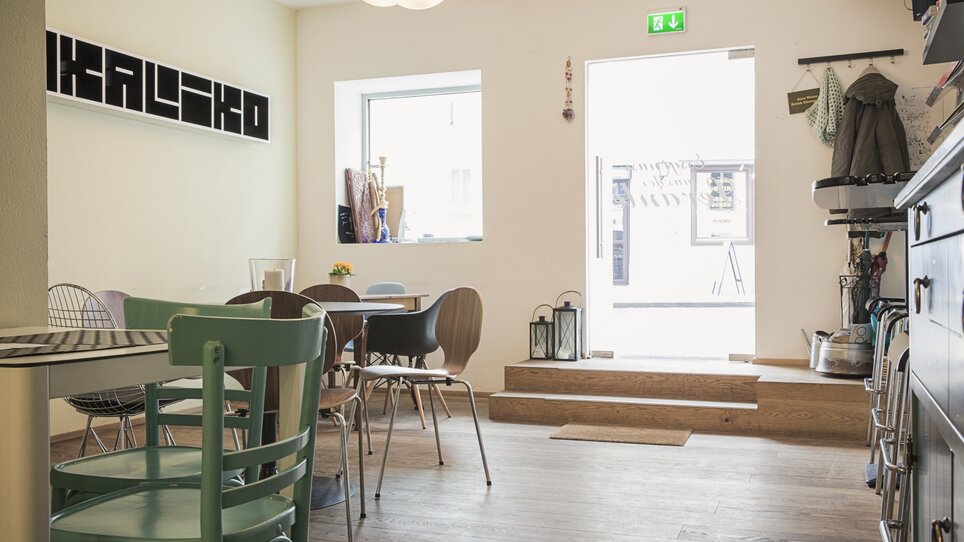 Vista interna di Bakaliko con tavoli e finestra. | © Bakaliko