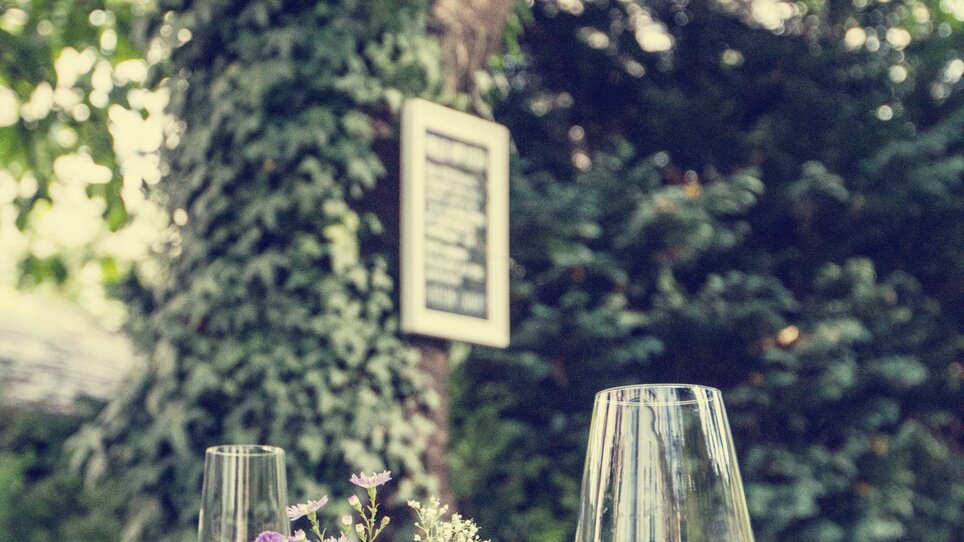 A cozy café with flowers and glasses on a table. | © Cafe Fotter