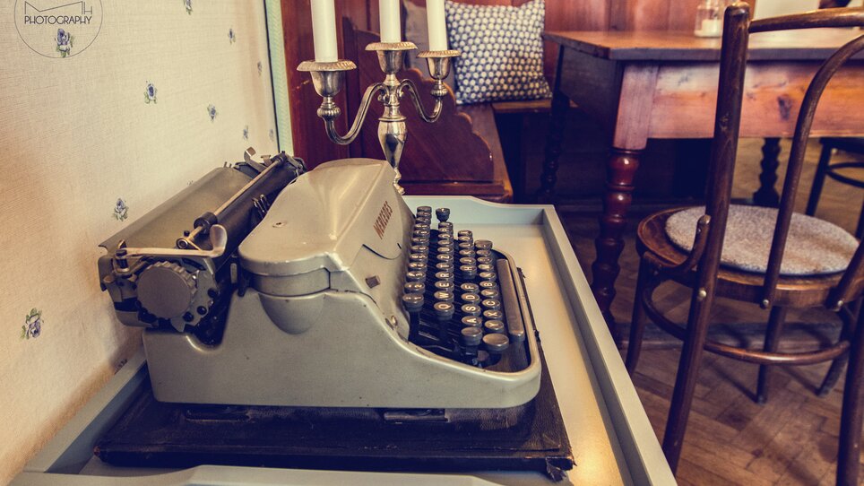 A vintage typewriter on a table in a cozy café. | © Cafe Fotter