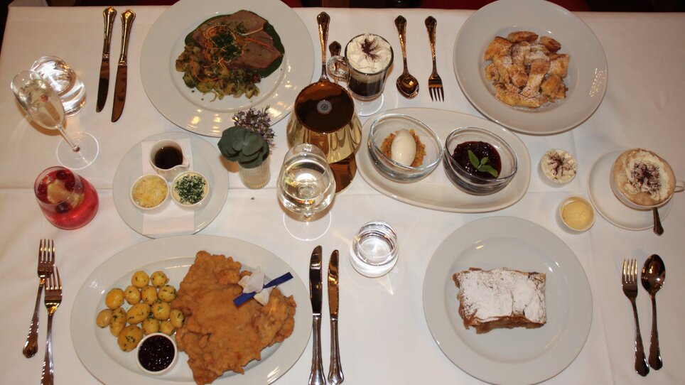A festive table view with various dishes and drinks. | © Café Herzog