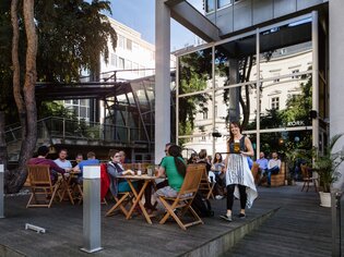 Draußen sitzende Gäste im Café Kork in Graz bei schönem Wetter. | © Cafe Kork