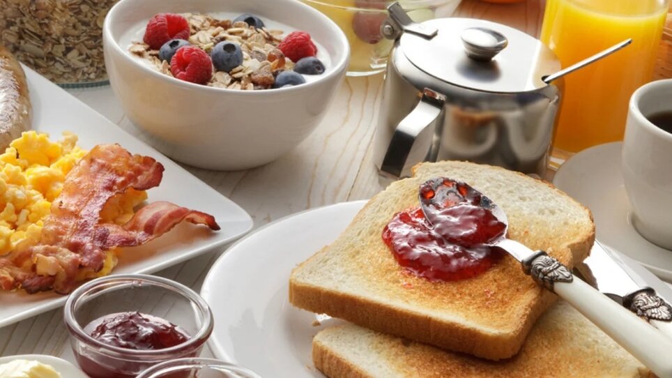A hearty breakfast with toast, jam, eggs, bacon, and fruit. | © Café Muhr
