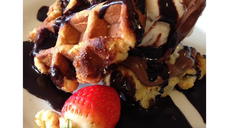 A dessert of waffles, ice cream, and chocolate sauce. | © Café Muhr