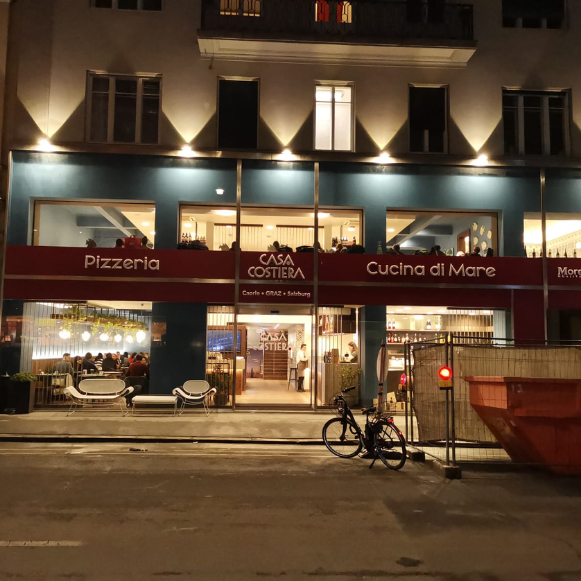 Casa Costiera restaurant in Graz, Pizzeria and Italian cuisine illuminated at night. | © Casa Costiera