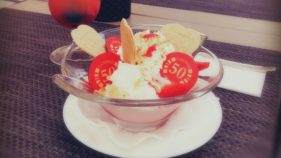 Ein bunter Cocktail und ein Eisbecher auf einem Tisch im Casino-Restaurant Graz. | © Casino Graz