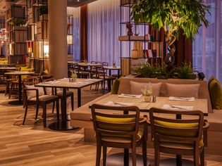 Modern restaurant in IntercityHotel Graz featuring wooden floors and plants. | © IntercityHotel Graz