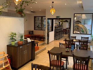 Atmosfera accogliente nel ristorante con tavoli e piante. | © R&D Gastro OG