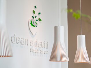 Logo di dean&david con lampade pendenti in un ambiente moderno. | © dean&david