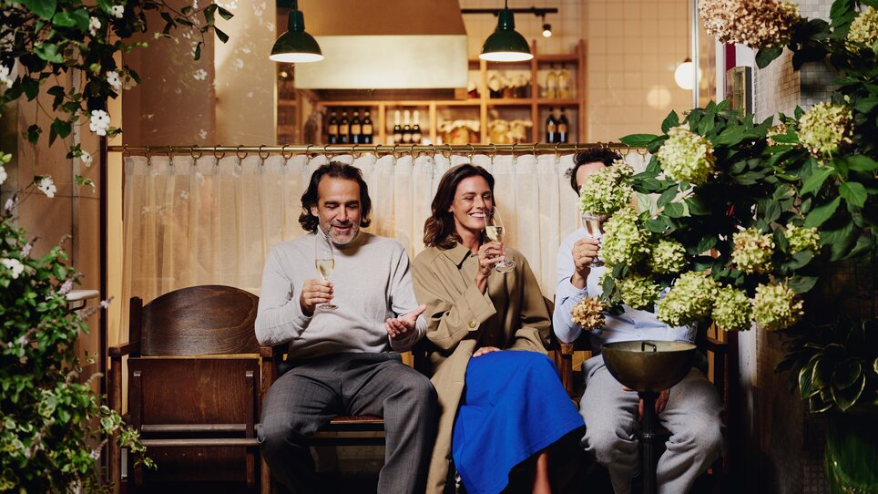 Tre persone si godono un drink nell'accogliente atmosfera davanti al ristorante “Der Steirer”. | © Florian Weitzer Hotels & Restaurants