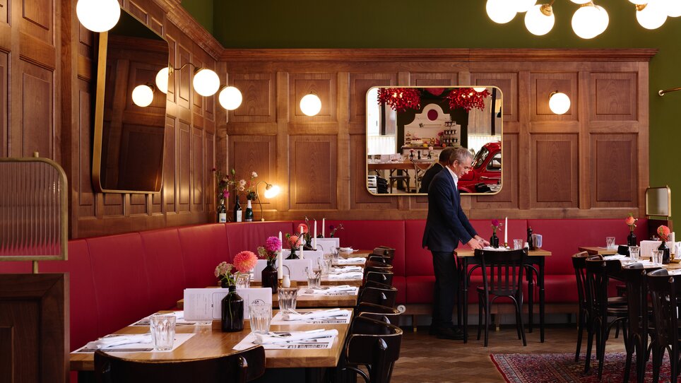 Ristorante rustico con elementi di legno e illuminazione elegante. | © Florian Weitzer Hotels & Restaurants