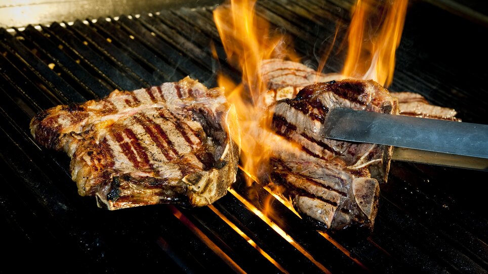 Grilled steaks on the grill with flames. | © El Gaucho - Werner Krug