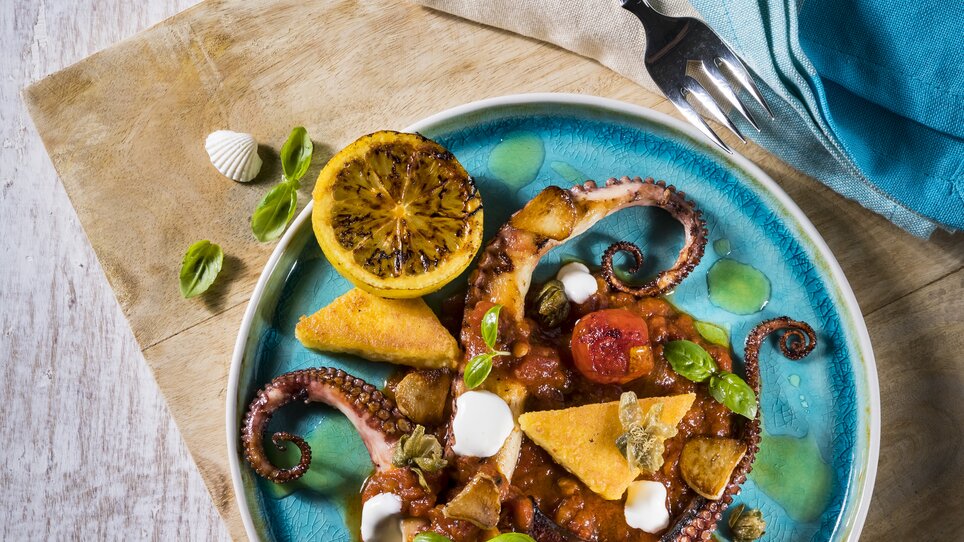 Delicious octopus dish with tomatoes and citrus on a plate. | © El Pescador - Werner Krug