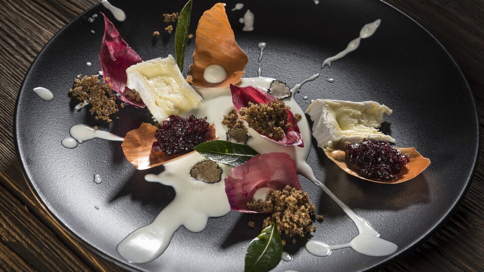An artfully arranged plate with cheese, petals and sauce. | © El Pescador - Werner Krug