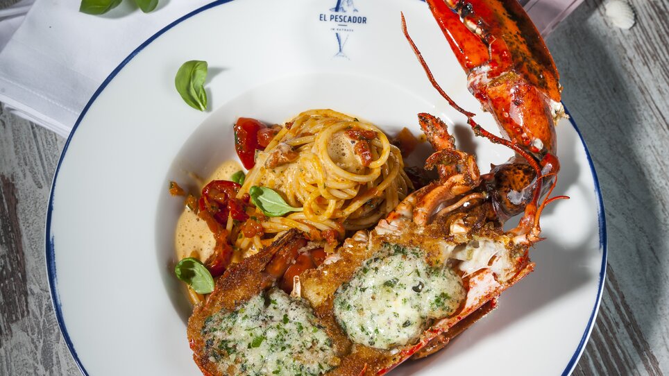 Lobster with pasta, herb butter, and sides on a plate. | © El Pescador - Werner Krug