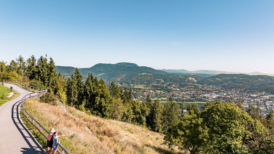 Ausblick auf Graz mit Berglandschaft und Wanderweg. | © Graz Tourismus - Mias Photoart