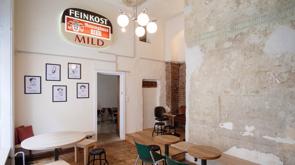 Innenansicht eines Cafés mit Holzböden und Tischen. | © Leitner Daniel