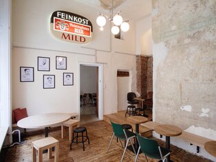 Innenansicht eines Cafés mit Holzböden und Tischen. | © Leitner Daniel
