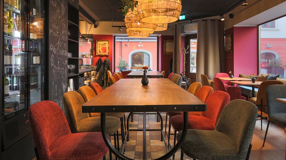 Modern bistro with cozy interior, stylish lamps, and red color scheme. | © Makinson Media