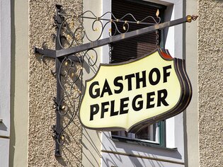 Sign of Gasthof Pfleger in Graz, mounted on a wall. | © Pfleger