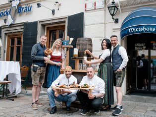 Friendly team with food and drinks in front of Glöckl Bräu in Graz. | © Conny Photography