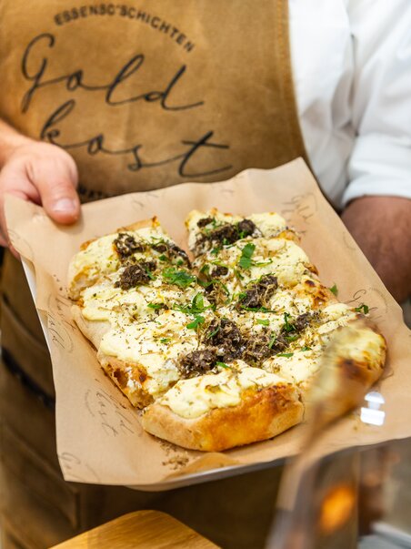 A freshly prepared dish with herbs and cheese on a tray in Graz. | © Paul Stajan