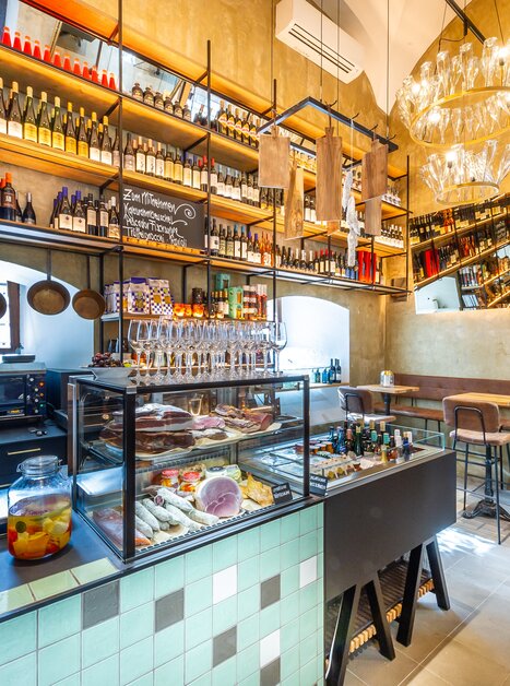 Modern dining space featuring a variety of offerings and wine shelves. | © Paul Stajan