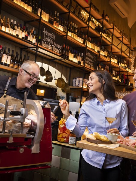 Two guests enjoy food and drinks in a gourmet shop. | © Graz Tourismus - Werner Krug