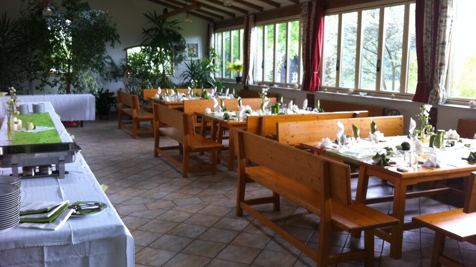 Cozy dining room in Heurigenschenke Sattler with tables and plants. | © Sattler