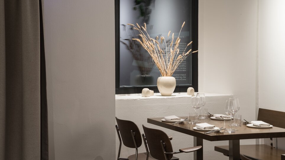 Ristorante moderno con tavolo elegante e decorazione floreale. | © Kabuff