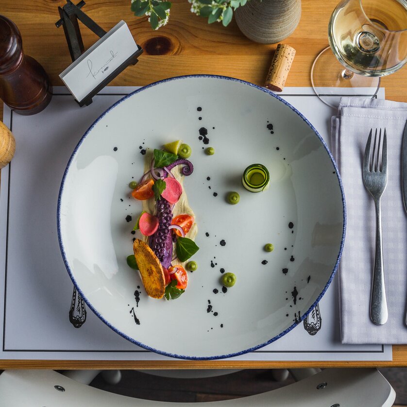 Un piatto artisticamente disposto con pesce fresco e verdure.