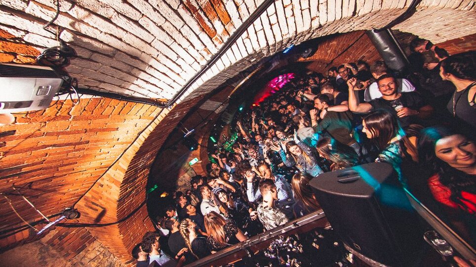 Voller Club mit Menschen auf der Tanzfläche und Dachgewölbe.