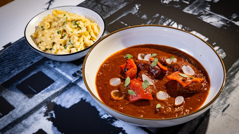 Herzhaftes Gulasch mit Paprika und Nockerl als Beilage, serviert in Graz. | © Kreuzwirt am Rosenberg in Graz