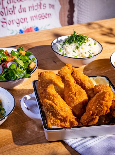 Knuspriges Backhendl mit Beilagen und frischen Salaten. | © Kreuzwirt am Rosenberg in Graz