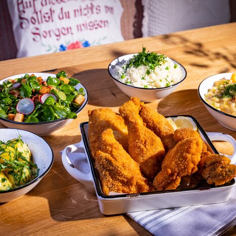 Knuspriges Backhendl mit Beilagen und frischen Salaten. | © Kreuzwirt am Rosenberg in Graz