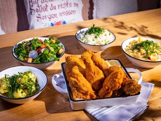Knuspriges Backhendl mit Beilagen und frischen Salaten. | © Kreuzwirt am Rosenberg in Graz