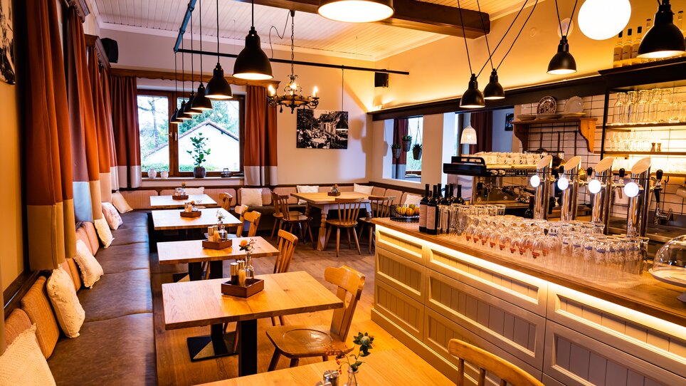 Gemütliches Restaurant mit Holzstühlen und beleuchtetem Tresen. | © Kreuzwirt am Rosenberg in Graz