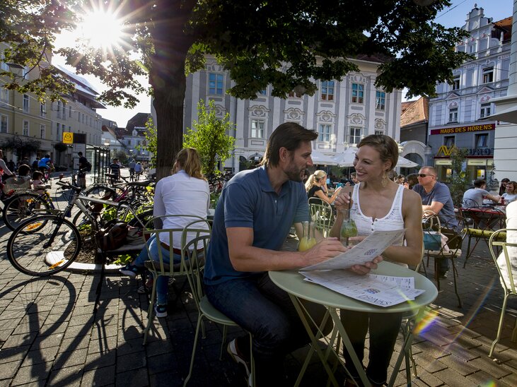 Couple enjoying time at Kunsthauscafé in Graz, surrounded by people and bicycles. | © Graz Tourismus - Tom Lamm