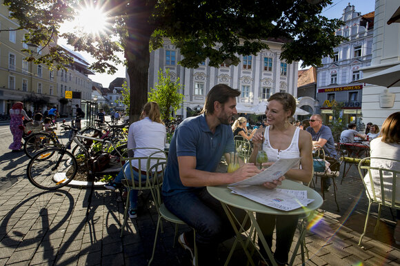 Paar genießt Zeit im Kunsthauscafé in Graz, umgeben von Menschen und Fahrrädern. | © Graz Tourismus - Tom Lamm