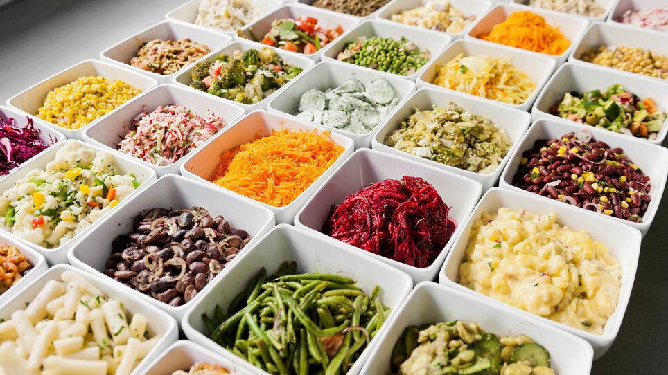 Vielfältige Servierschalen mit verschiedenen frischen Salaten und Beilagen. | © Mangolds