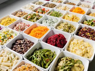 Varietà di piatti in ciotole con insalate fresche e contorni. | © Mangolds