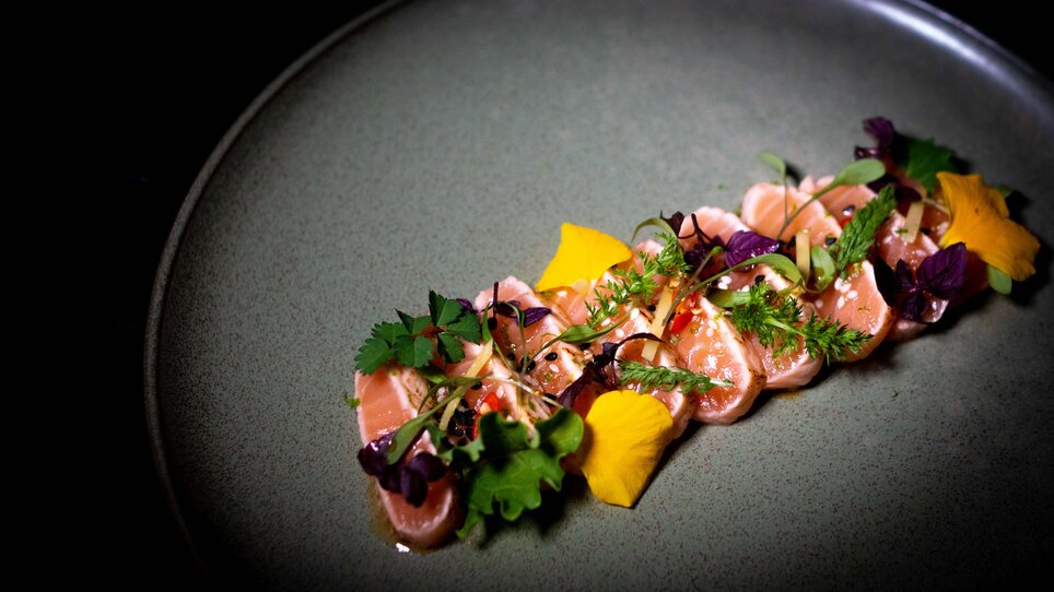 Delicate fish platter with fresh herbs and edible flowers.