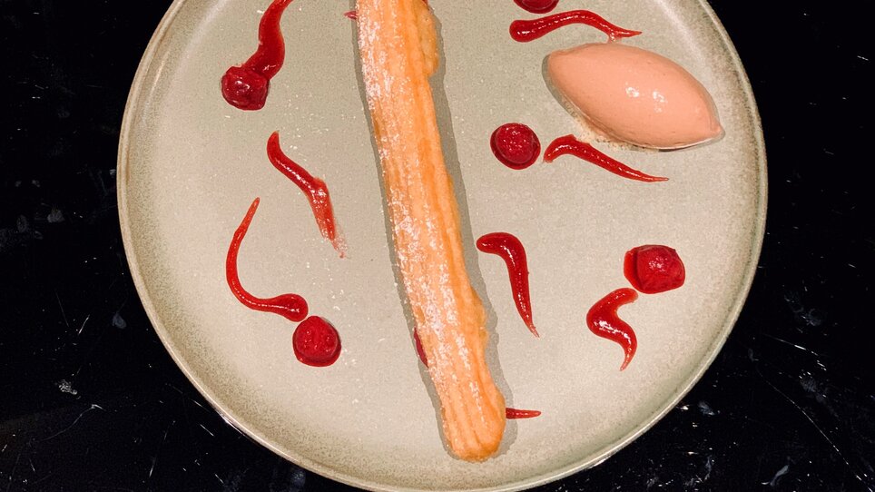Dessert featuring churro and sorbet served on a plate.