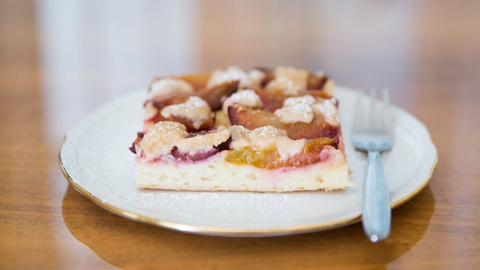Ein Stück Obstkuchen mit Pflaumen auf einem Teller. | © Svetlana Gombats Photography 