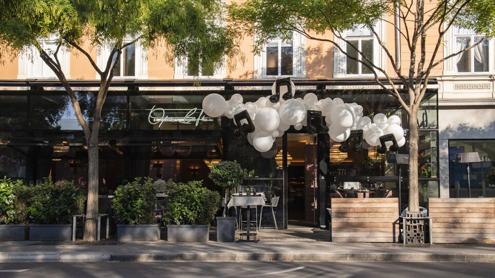 Modern restaurant facade with balloon decoration and colorful atmosphere. | © Jauk Katharina