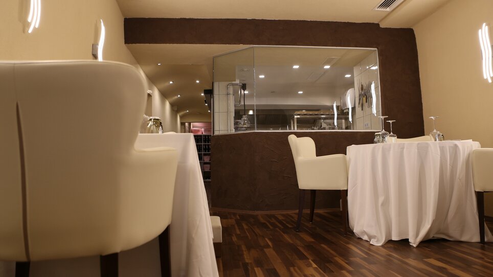 Elegant restaurant with tables and kitchen in the background. | © Restaurant Artis