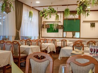 Cozy restaurant with plants and set tables. | © sReindl